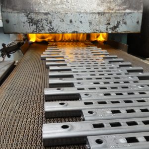 Bauteile in Wärmebehandlung auf Förderband